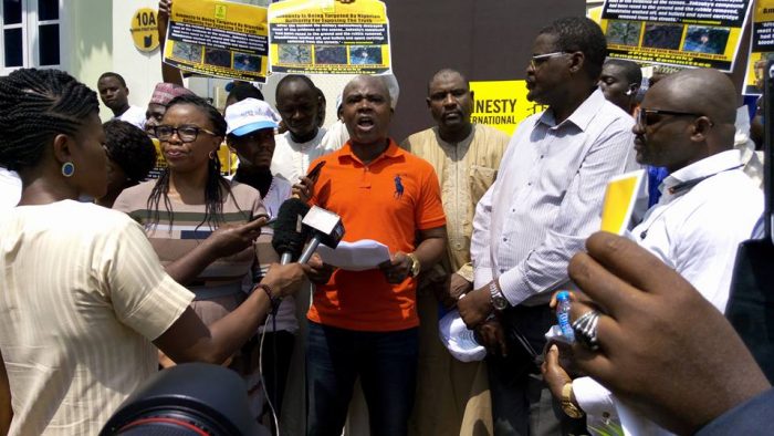 Jude Ndukwe, Leader of MANTRA and co-convener of the rally presenting the CSOs official paper at the rally youth civil society Amnesty International solidarity rally