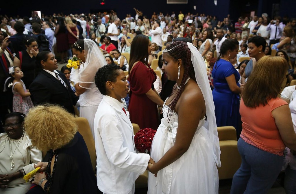  Joyce and Gabrieli (R) hold hands at what was billed as the world's largest communal gay wedding on December 8, 2013 in Rio de Janeiro, Brazil. 130 couples were married at the event which was held at the Court of Justice in downtown Rio. In May, Brazil became the third country in Latin America to effectively approve same-sex marriage via a court ruling, but a final law has yet to be passed. (Photo by Mario Tama/Getty Images)