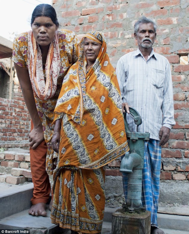 Tall order: Gigantism sufferer Siddiqa Parveen, pictured with her parents, from south Dinajpur, West Bengal, is estimated to be 7ft 8in tall as a result of a tumour on the pituary gland (Photo Credit: Daily Mail)