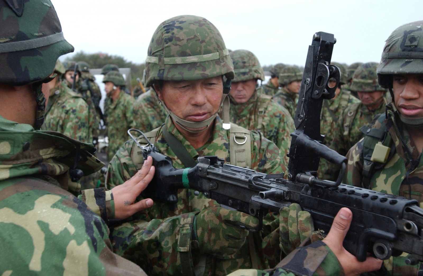 American Soldiers demonstrate the M249 Squad Automatic Weapon to a Japanese soldier of the 39th Infantry Regiment, Japan Ground Self-Defense Force, Nov. 2. during Exercise Orient Shield 2005.  (U.S. Army photo by Staff Sgt. Jonathan Crane, 304th MPAD.)