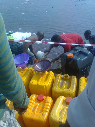 Residents of Lagos scooping fuel | Photo: Vanguard