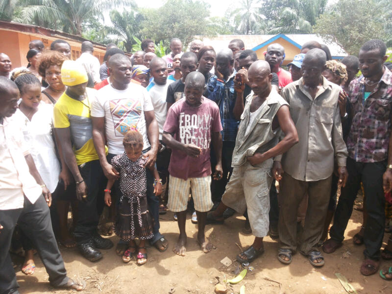 MARCH 8, 2014: Younger brother of the deceased, Isaiah Asika (centre) with the daughter of the deceased in Mgbee, Orlu LGA, Imo State (Photo Credit: Douglas Nwune/The Trent)