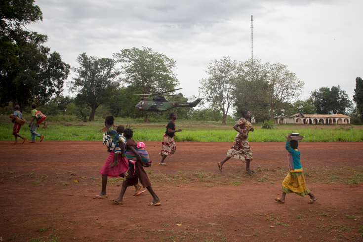 Grimari. Christians who took refugee at the Catholic mission of Grimari to flee the fighting between Seleka and Antibalakas, are fastly walking back to their home to get food and belongings during a break of fighting, thanks to the arrival of some Sangaris renforts. Grimari is being attacked by Antibalakas for 2 days as it is the gate to the Ouaka region that is still controlled by ex Seleka fighters whose general Ali Mahamat Darrassa is relatively appreciated by both muslims and christians for having fought and expelled others Seleka who were installing terror among the city communities. Sangaris troops trust him, thinking he is the only way to keep Ouaka region out of violence. (Photo Credit: William Daniels/Panos)
