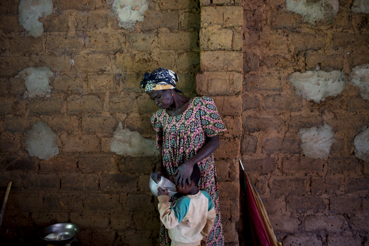 Grimari. A displaced woman gives water to her son. 4800 displaced christians took refugee at the Catholic mission of Grimari to flee the fighting between ex Seleka and Antibalakas, Grimari is being attacked by Antibalakas for 2 days as it is the gate to the Ouaka region that is still controlled by ex Seleka fighters whose general Ali Mahamat Darrassa is relatively appreciated by both muslims and christians for having fought and expelled others Seleka who were installing terror among the city communities. Sangaris troops trust him, thinking he is the only way to keep Ouaka region out of violence between christians and muslims. (Photo Credit: William Daniels/Panos)