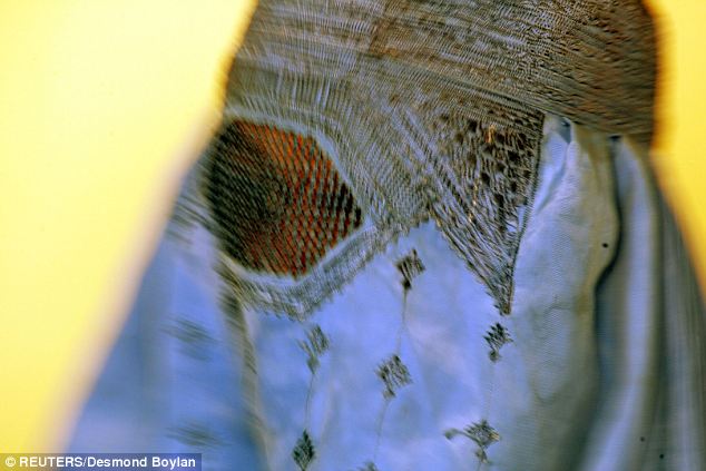 An Afghan woman wearing a traditional burqa: The parents of a teenage girl are under arrested after cutting off the ears and nose off a local cleric who, she claimed, had subjected her to a series of sex assaults