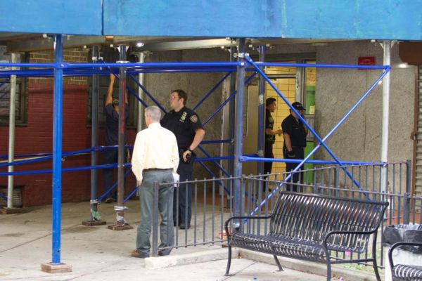 Investigators outside the Adams Houses building where a 20-year-old man was crushed to death in an elevator shaft on Monday, July 28, 2014 (Photo Credits: NY Daily)