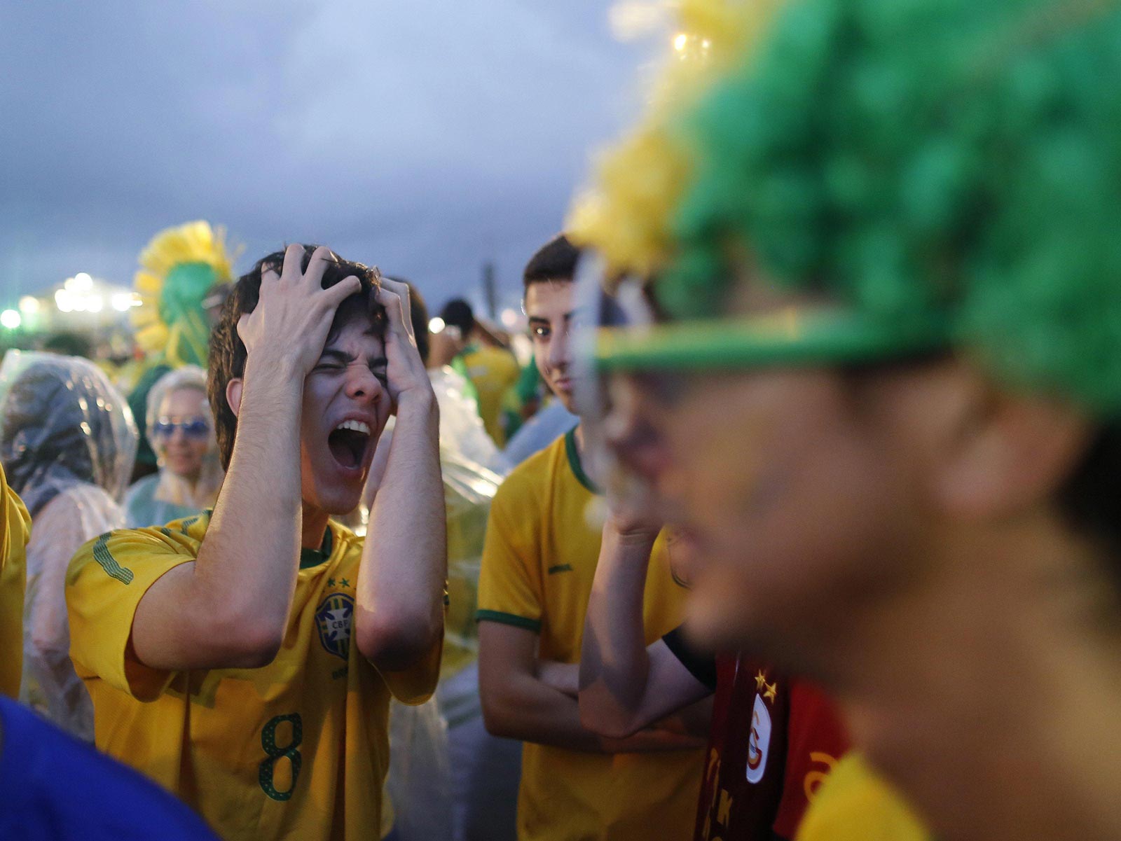 A Brazil soccer fan reacts in frustration as he watches his team play a World Cup semifinal match against Germany on a live telecast inside the FIFA Fan Fest area on Copacabana beach in Rio de Janeiro, Brazil, Tuesday, July 8, 2014. (Photo Credit: AP Photo/Leo Correa)