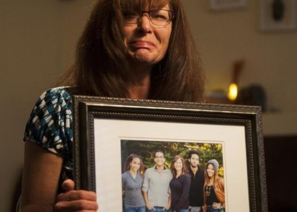 This photo, taken, Friday, Sept. 12, 2014, shows Susan Hunt holding a photo of her family, including her son, Darrien Hunt, at her home in Saratoga Springs, Utah. (Photo Credit: AP/Deseret News, Michelle Tessier)