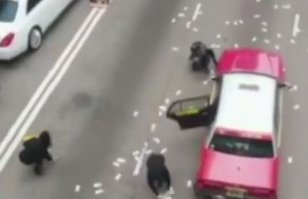 Crowd Gathered In The Middle Of The Road To Pick Money In Hong Kong (Photo Credit: Metro UK)
