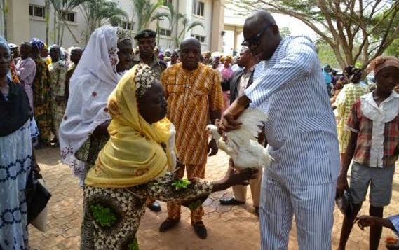 Governor Ayo Fayose giving a chicken to an elderly beneficiary of the Ekiti State Government Christmas giveaway on December 20, 2014 (Ekiti State Photo)