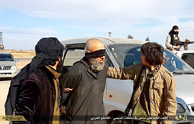 The victim was blindfolded and led to the execution spot by the ISIS militants, including one who appears to be a teenager. (Photo Credit: Mail Online)