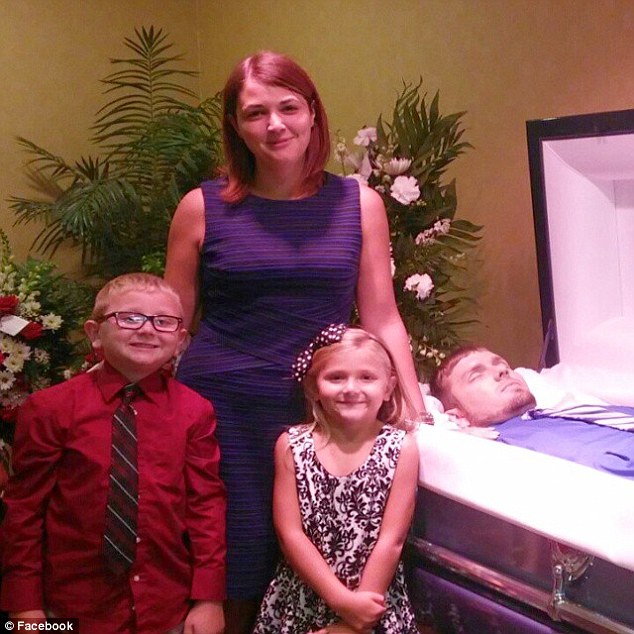 Eva Holland and her kids, Lucas and Ava, could be seen standing next to 26-year-old Mike Settles who was in an open casket at his funeral last week.