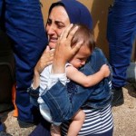 Hungarian-policemen-stand-by-a-miogrant-holding-a-baby-at-the-railway-station-in-the-town-of-Bicske-Hungary