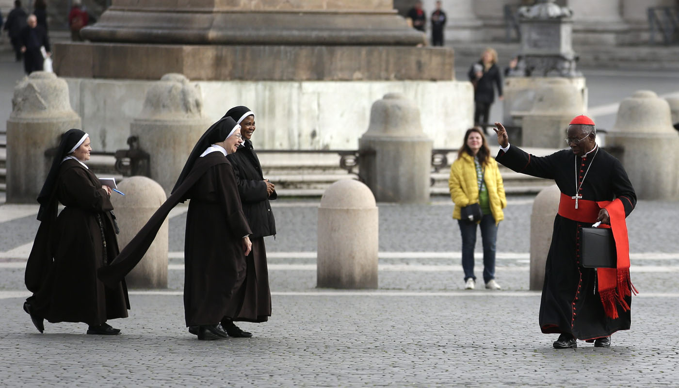 Cardinal Francis Arinze of Nigeria waves at nuns as he arrives for a meeting at the Synod Hall at the Vatican, March 8, 2013. | Reuters/Max Rossi