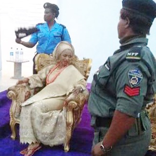 The policewoman fanning the Ooni of Ife's wife