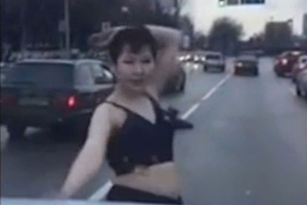 Woman stripped to bra and dances for cars in the middle of a busy road 