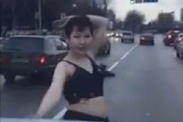 Woman stripped to bra and dances for cars in the middle of a busy road