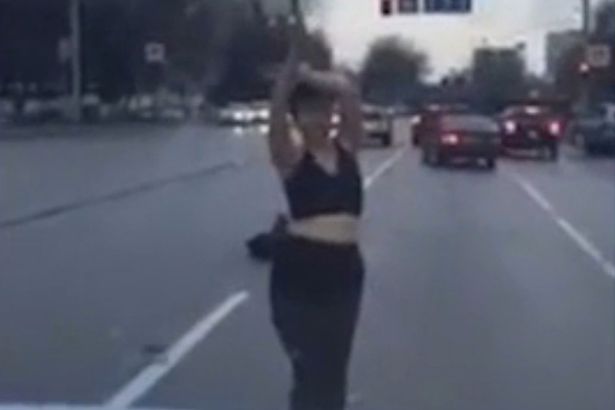 Woman stripped to bra and dances for cars in the middle of a busy road 