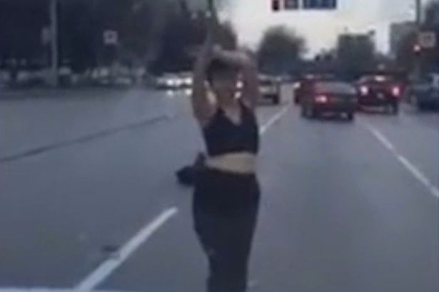 Woman stripped to bra and dances for cars in the middle of a busy road