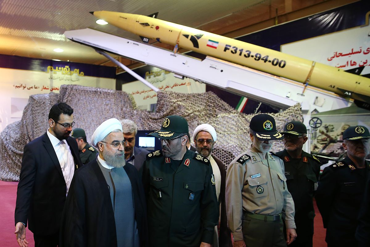 A handout picture released by the official website of the Iranian President Hassan Rouhani shows him (2nd L) and Defence Minister Hossein Dehghan (C) during the Defence Industry Day ceremony to unveil the country's latest domestically produced surface-to-surface Fateh (Winner) 313 missile on August 22, 2015 in Tehran. | AFP/Iranian Presidency Photo