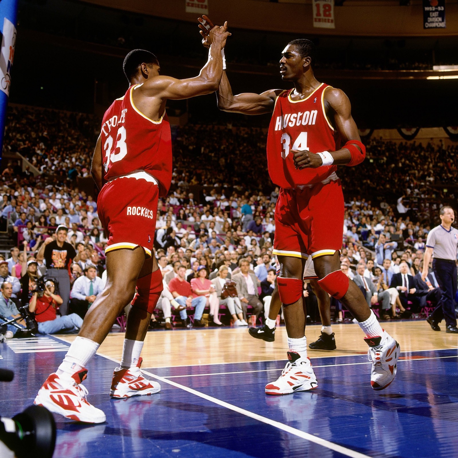 Hakeem Olajuwon #34 of the Houston Rockets high fives Otis Thorpe #33 during Game Four of the NBA Finals played on June 15, 1994 at Madison Square Garden in New York, New York. | (c) Andrew D. Bernstein/NBAE via Getty Images