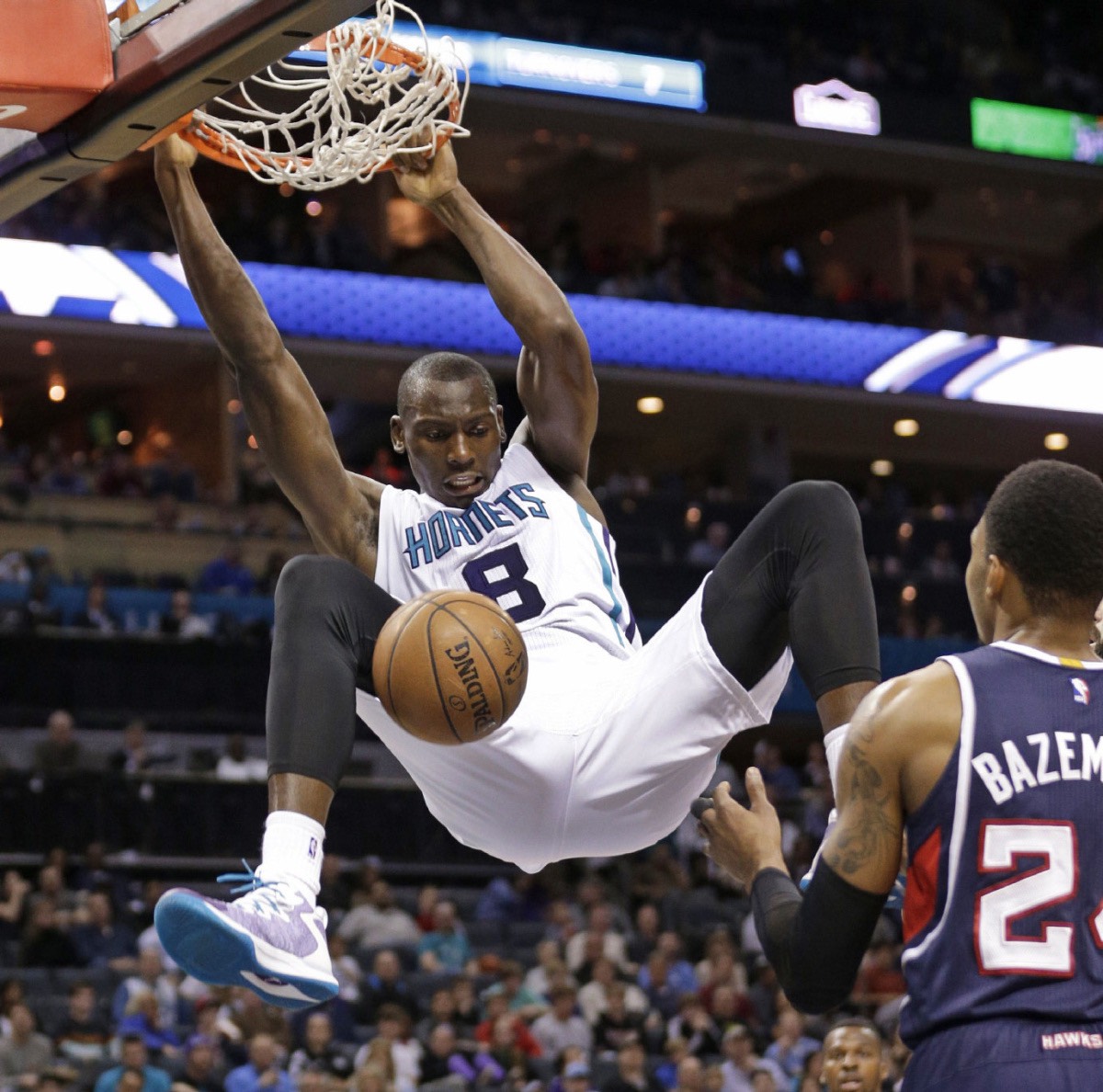 Charlotte Hornets' Bismack Biyombo (8) dunks against Atlanta Hawks' Kent Bazemore, right, during the second half of an NBA basketball game in Charlotte, N.C., Saturday, March 28, 2015. The Hornets won 115-100. | AP P/Chuck Burton