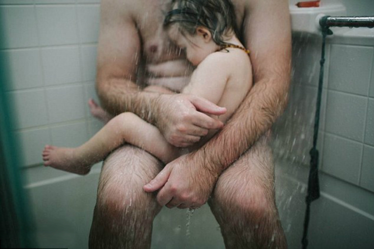 Photographer Heather Whitten shared the naked photo of her husband, Thomas cradling their son in the shower | Heather Whitten