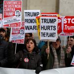 People hold signs to show solidarity with the Women’s March in Washington and many other marches in several countries, in Madrid