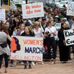 Participants of a rally regarding women’s rights hold placards as they march in Wellington, New Zealand