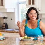 vegetables salad Overweight Woman Eating Healthy Meal in Kitchen