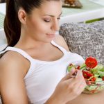 Beautiful pregnancy eating salad