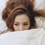 woman under bed sheet