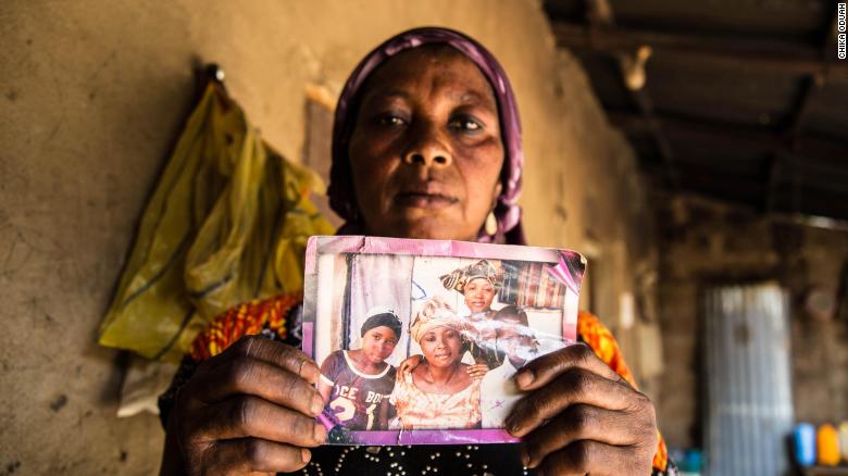 Rebecca Sharibu holds up a photograph that shows her daughter Leah, seated on the left in a black shirt. Leah was kidnapped in February 2018 from her school in the town of Dapchi in northern Nigeria by members of the terrorist organization Boko Haram. Photo by Chika Oduah. April 2018.