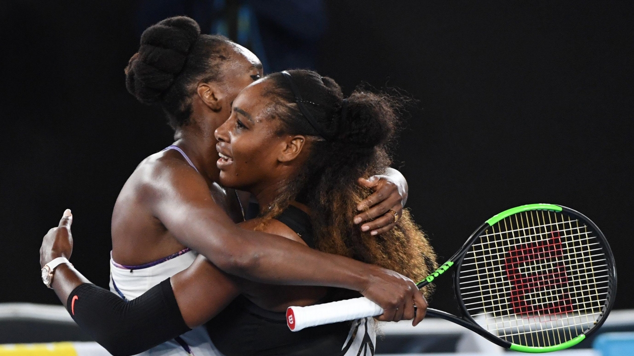 Serena Williams (R) hugs her sister Venus Williams