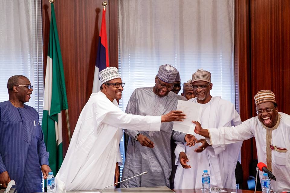 A WAEC official presents an attestation certificate to President Muhammadu Buhari in Aso Rock on November 2, 2018