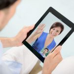 14937278-a-young-couple-talking-to-each-other-via-online-video-chat