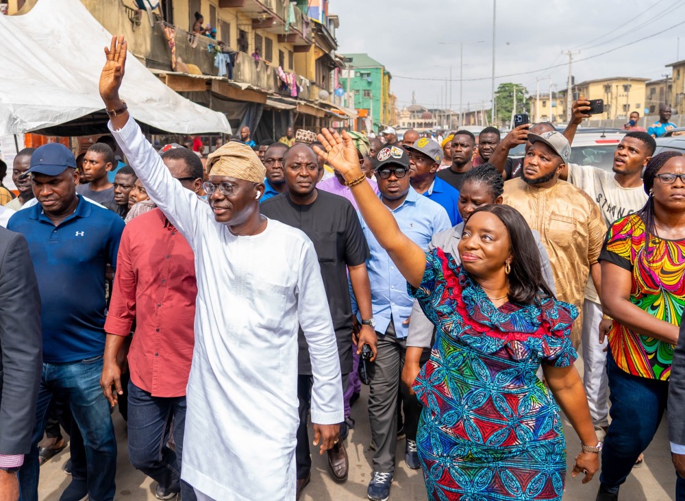 Lagos State Governor Babajide Sanwo-Olu and his wife, Ibijoke, wave at the crowd at Eiyekole Ward E3 on Adeniji Adele Road, Lagos Island, as the first couple arrive to cast their vote in the Presidential Election on February 25, 2023. | Twitter