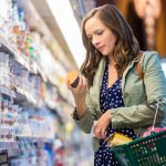 food label, reading food label in supermarket,  Woman reading food labels at grocery store