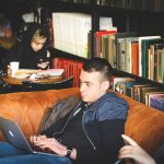 library, books, bookshelf, laptop, man, remote work, alireza-attari-kowL8z4ITXw-unsplash