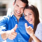 Smiling couple with thumbs up