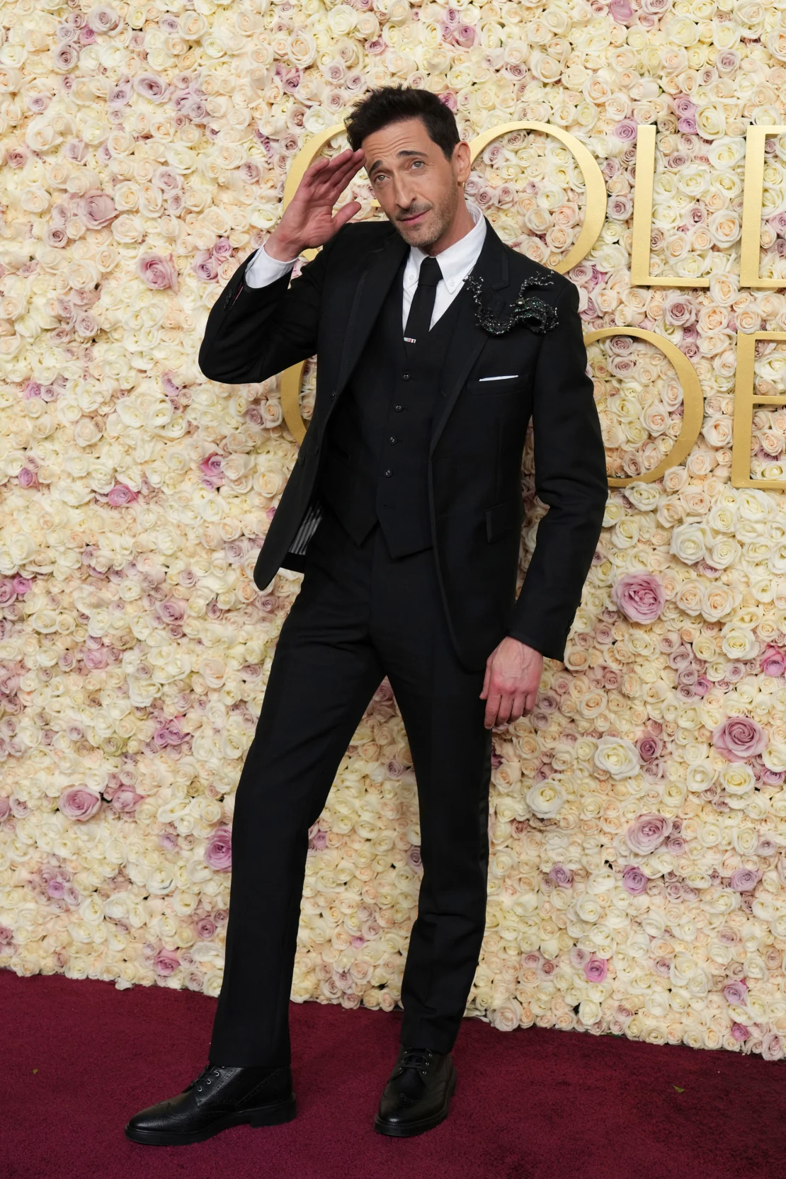 Adrien Brody wore a three-piece Thom Browne tuxedo adorned with a large brooch at the 82nd Golden Globes Awards held at the Beverly Hilton, Beverly Hills, California on Sunday, January 5, 2025. | Jordan Strauss/Invision/AP