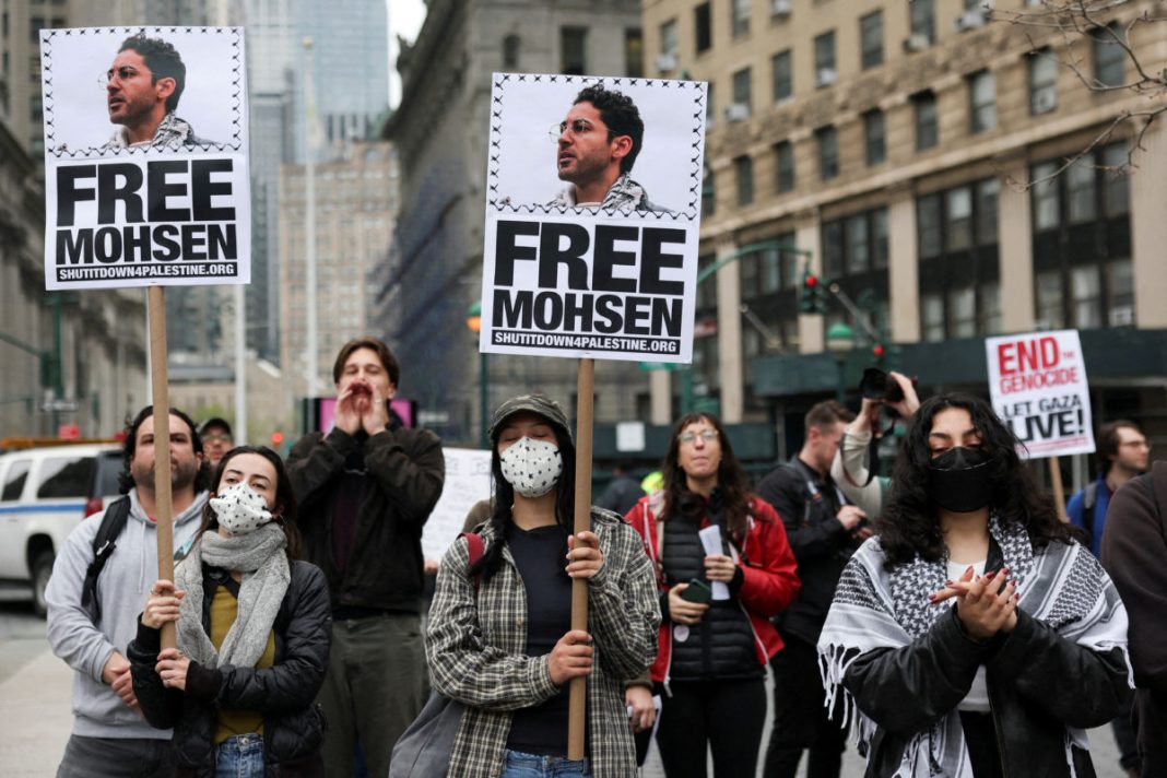 Demonstrators hold placards that read 