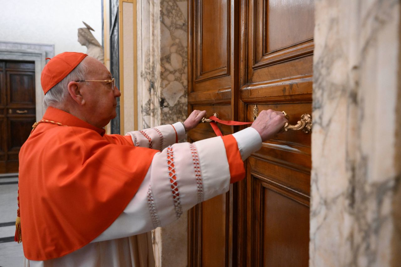 Cardinal Camerlengo Kevin Joseph Farrell seals the door to the papal bedroom and studio at the Vatican on Monday, April 21, 2025. | Vatican Media/AP