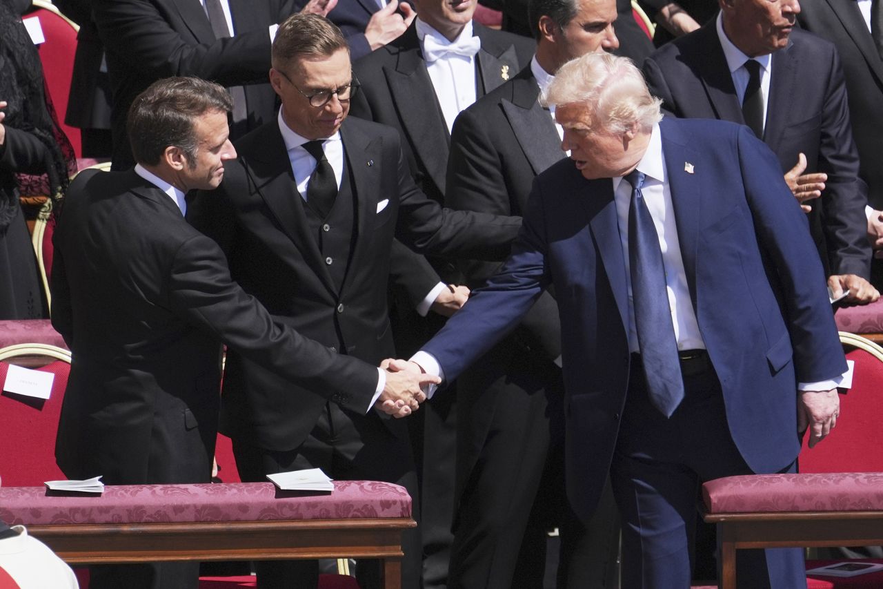 President Donald Trump, right, shakes hands with French President Emmanuel Macron, left, as Finland's President Alexander Stubb, looks on, as they attend the funeral of Pope Francis on Saturday, April 26, 2025. | Evan Vucci/AP