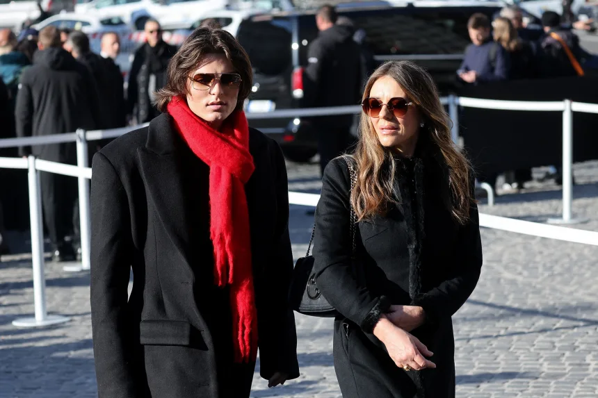 Actor Liz Hurley and her son Damian Hurley, wearing a scarlet red scarf in honour of Valentino’s signature hue, attend the funeral at the Basilica of Santa Maria degli Angeli e dei Martiri in Rome on Friday, January 23, 2026. | Yara Nardi/Reuters