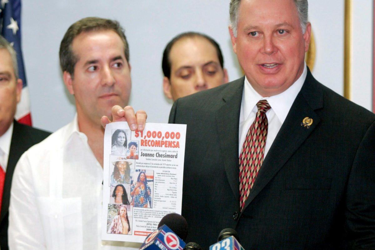 In 2005, Jorge Mas Santos, chairman of the board for the Cuban American Foundation, listens to Albio Sires, New Jersey state assembly speaker of the House, holds a reward pamphlet for Assata Shakur, who fled to Havana. Shakur was wanted for the shooting death of a New Jersey state trooper in 1979. File Photo by John Riley/EPA