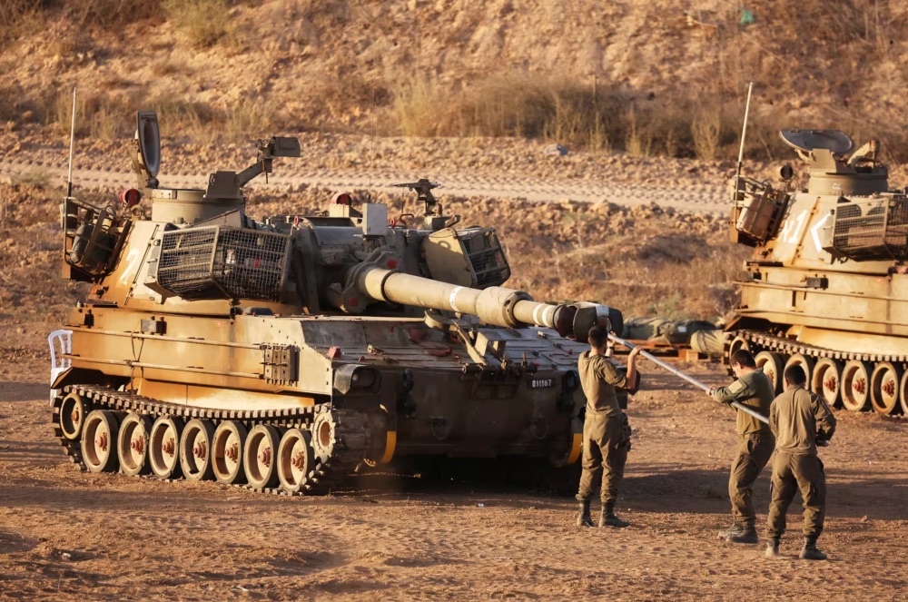 Israeli soldiers work on a self-propelled artillery Howitzer at the border with Gaza.Jack Guez / AFP via Getty Images