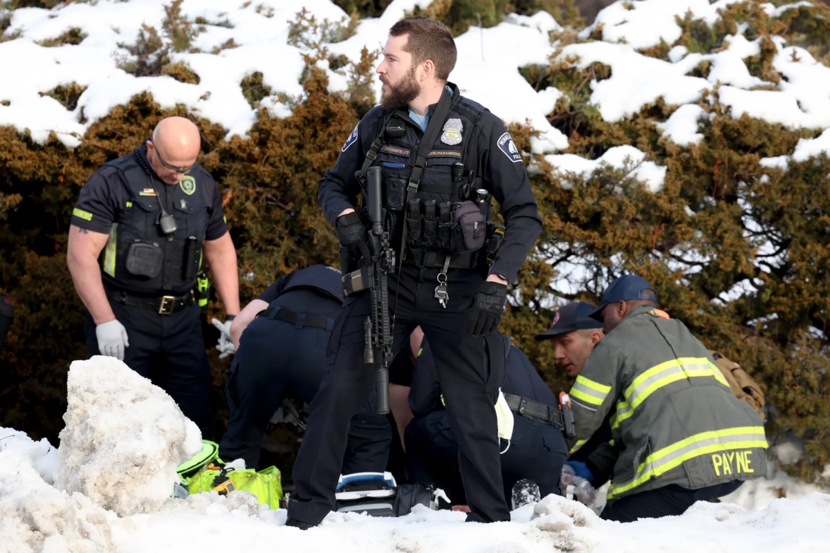 A Minneapolis police officer stands guard while emergency medical technicians administer aid to a person at the scene of a shooting in Minneapolis on Wednesday, January 7, 2026. | Ellen Schmidt/MinnPost via AP 