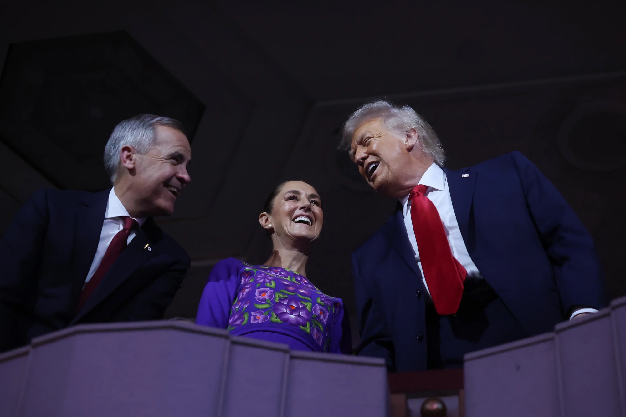 Mark Carney and Donald Trump (joined by Mexico's President Claudia Sheinbaum) shared a much lighter exchange during the FIFA World Cup 2026 draw at the Kennedy Center in D.C. on Dec. 5, 2025. | Hector Vivas—Getty Images
