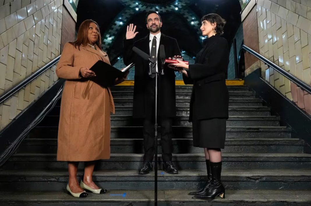 New York Attorney General Letitia James administers the oath of office to mayor-elect Zohran Mamdani as his wife, Rama Duwaji, holds two Qurans.